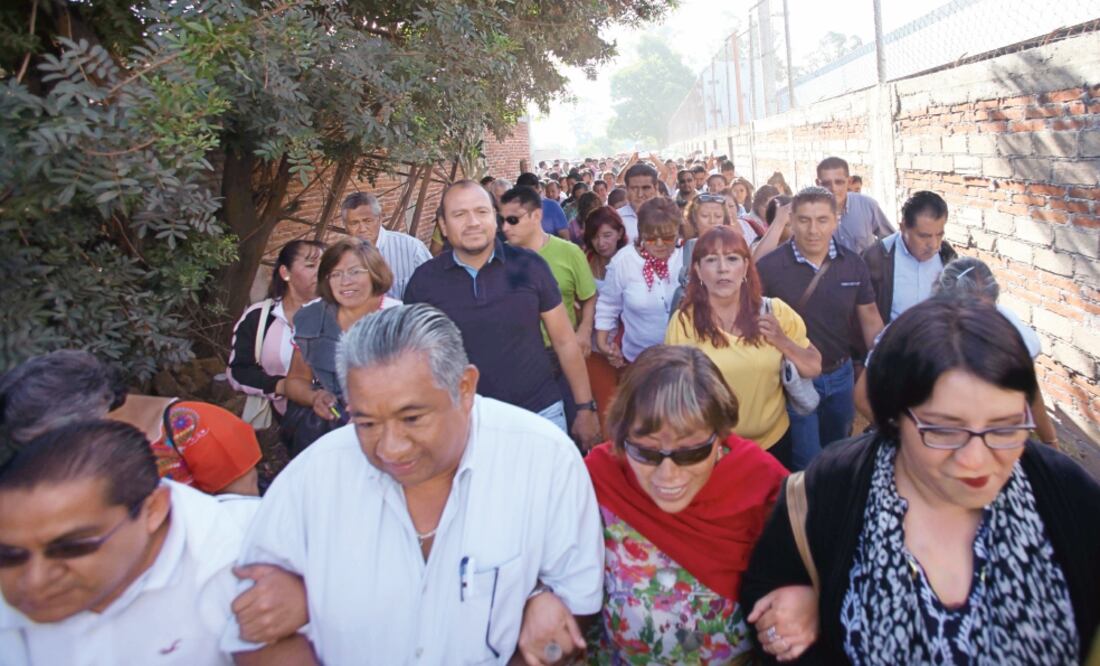 Fuera de las instalaciones de la IEEPO, Francisco Villalobos (al centro con playera negra), secretario de Organización de la Sección 22, se reunió con los trabajadores a quienes convocó a rechazar las nuevas normas del instituto (VALENTE ROSAS)