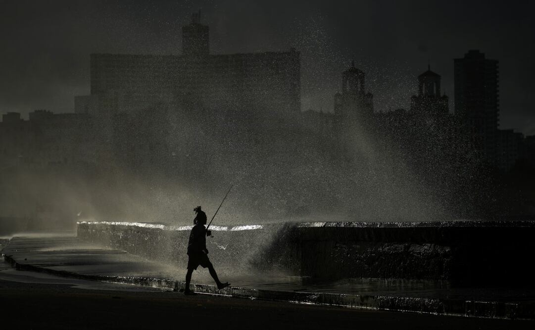 Una persona pesca a lo largo del malecón mientras las olas rompen en La Habana, el lunes 21 de octubre de 2024. Foto: AP
