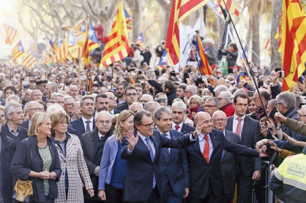 El presidente de Cataluña, Artur Mas (al centro), saluda a miles de simpatizantes que lo acompañaron, en Barcelona, a la corte donde declaró (ALBERT GEA. REUTERS)