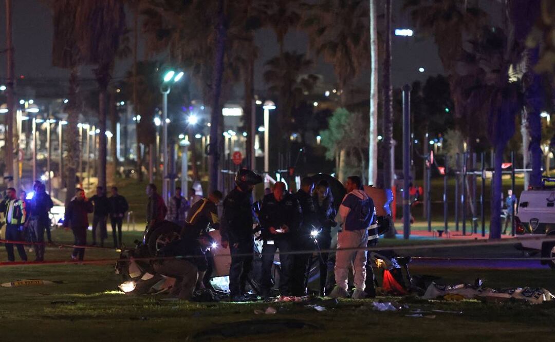 La policía israelí se reúne alrededor de un automóvil volcado en el lugar de un ataque en Tel Aviv. Foto: AFP