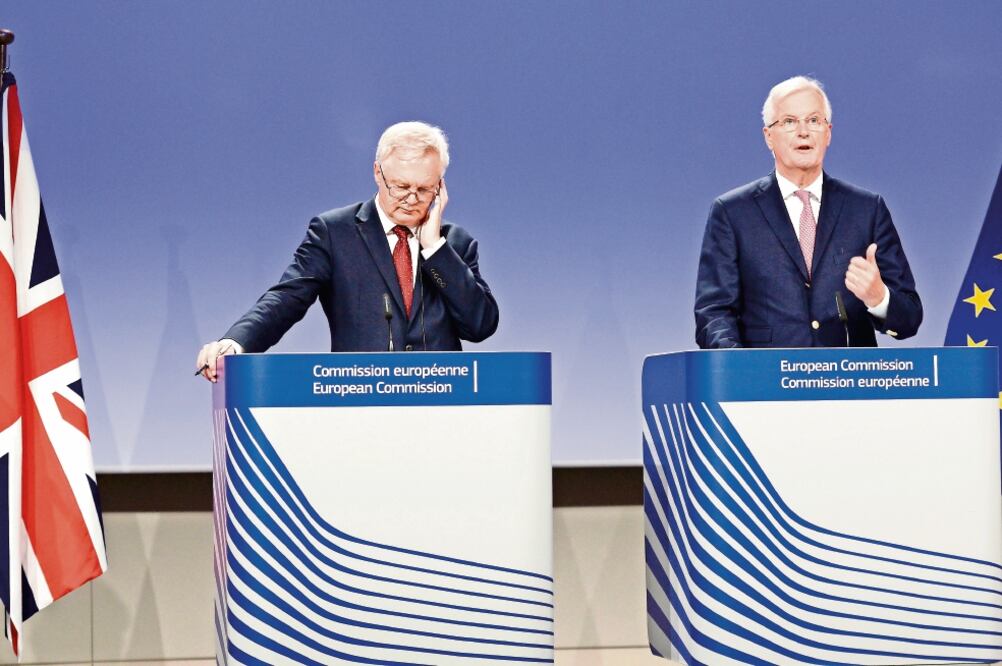 El secretario británico a cargo del Brexit, David Davis, escucha al jefe negociador europeo, Michel Barnier, durante una sesión con los medios, en Bruselas. (THIERRY CHARLIER. AFP)