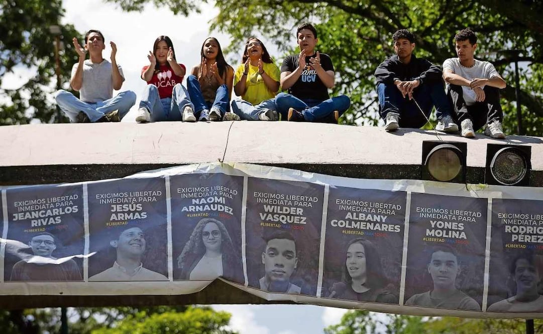 Estudiantes sostienen una pancarta con imágenes de presos políticos, en Caracas. Foto: EFE