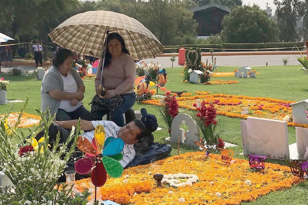 Sobre las tumbas los visitantes tendieron coloridos tapetes de flor de cempasúchil y colocaron veladoras.  (REBECA JIMÉNEZ. EL UNIVERSAL)