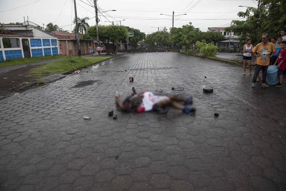 El cuerpo quemado de un hombre yace en el suelo de una calle en Managua (Foto: EFE)