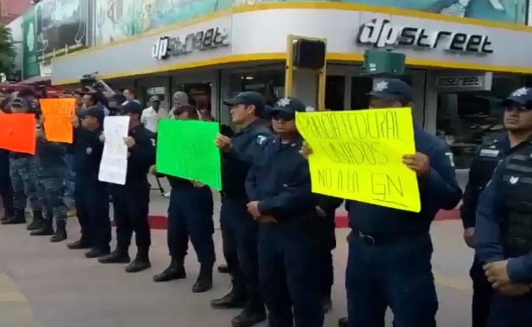 Los agentes portaron cartulinas donde dicen que no quieren ser obligados a renunciar y ser parte de la Guardia Nacional. Foto: Especial   