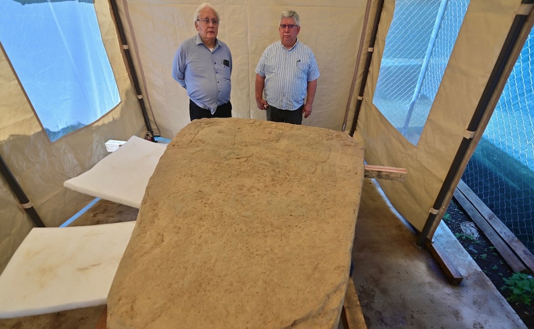 Los arqueólogos mexicanos Lino Espinoza y Alberto Vázquez, del INAH, posan con una estela de 2,5 toneladas hallada en un sitio arqueológico en Coatepec, Veracruz. Foto: AFP.