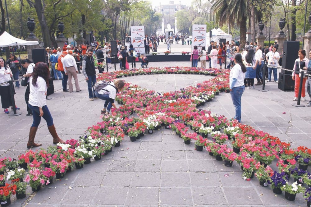 En la explanada del Monumento a los Niños Héroes varias mujeres crearon un lazo usando macetas con coloridas flores (ALEX CRUZ. EFE)