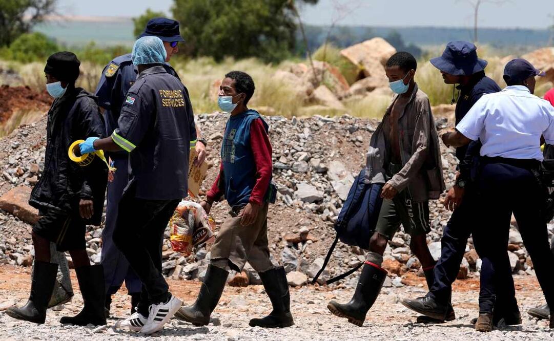 Policías escoltan a mineros ilegales después de ser rescatados de una mina de oro abandonada donde pasaron meses en Stilfontein, Sudáfrica, el 14 de enero de 2025. Foto: AP