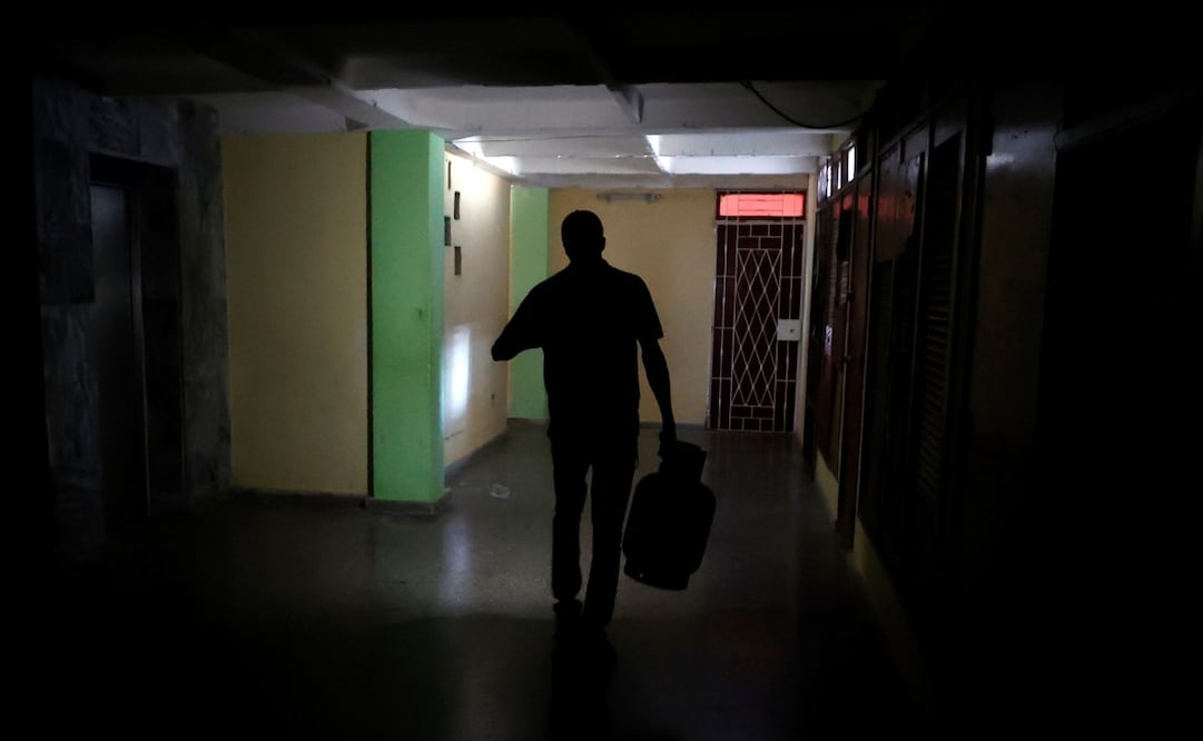 Una persona camina al interior de un edificio durante un apagón, en La Habana, Cuba. Foto: EFE