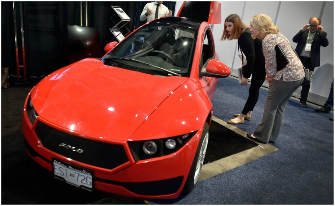 Asistentes examinan Electra Meccanica Solo, un vehículo eléctrico durante CES 2018 en el Centro de Convenciones de Las Vegas.