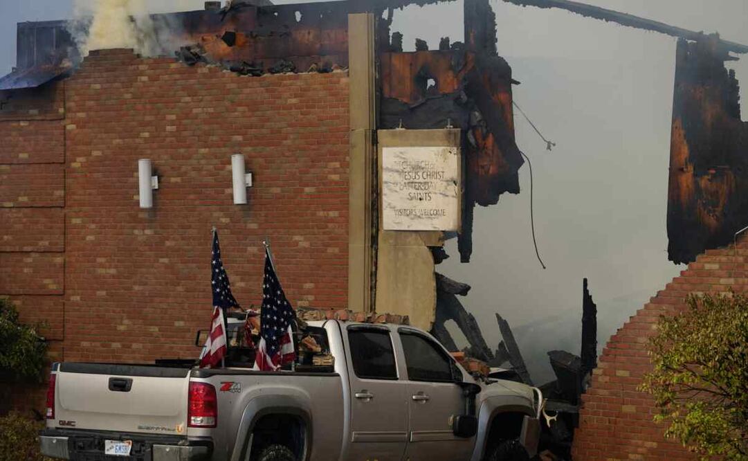 Un vehículo que fue embestido contra el edificio está rodeado de humo en la Iglesia de Jesucristo de los Santos de los Últimos Días en Grand Blanc, Michigan, el domingo 28 de septiembre de 2025, / Foto: (Lukas Katilius/The Flint Journal via AP)