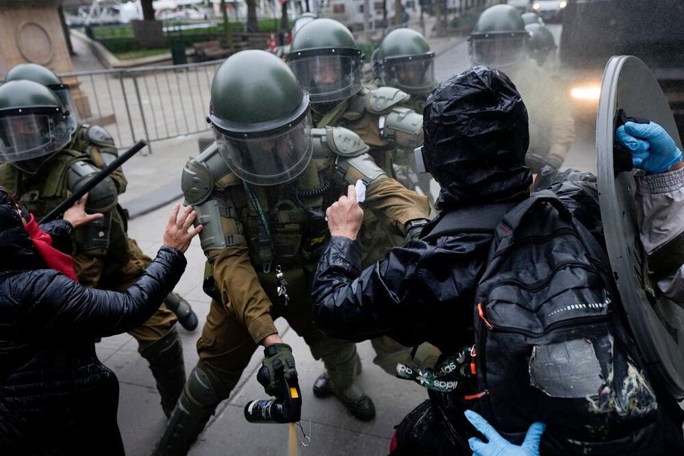 Manifestantes chocan con la policía durante una marcha que conmemora el 50 aniversario de un golpe militar liderado por el general Augusto Pinochet frente al palacio presidencial de La Moneda en Santiago, Chile. FOTO: AP