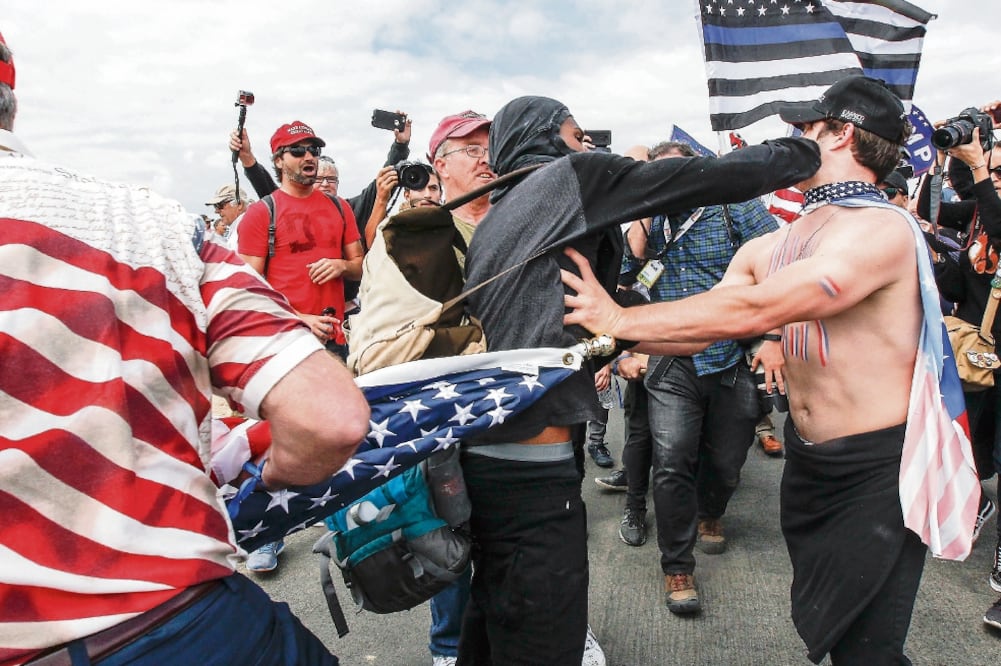 Simpatizantes del presidente Donald Trump y ciudadanos que están contra el gobierno del magnate se enfrentaron a golpes ayer durante una manifestación en Huntington Beach, California. (AP)