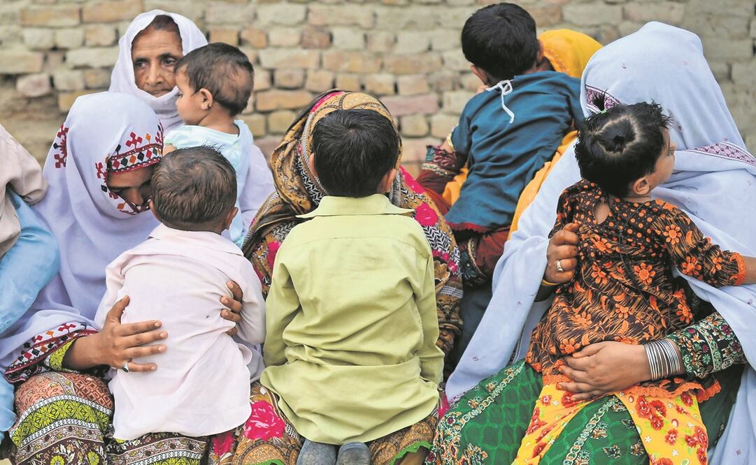 Paquistaníes sostienen a sus hijos infectados por VIH, mien- tras se reúnen en una casa. Foto: ARCHIVO. AFP
