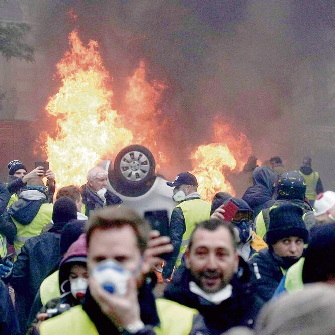 Manifestantes con chalecos amarillos se enfrentaron ayer a la policía e incendiaron vehículos cerca del Arco del Triunfo de París, Francia. Foto: YOAN VALAT. EFE