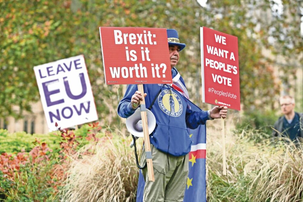 Un manifestante contrario al Brexit sostiene, en un camino en Londres, pancartas preguntándose si el proceso lo va le y demanda que los británicos voten. (DANIEL LEAL-OLIVAS. AFP)