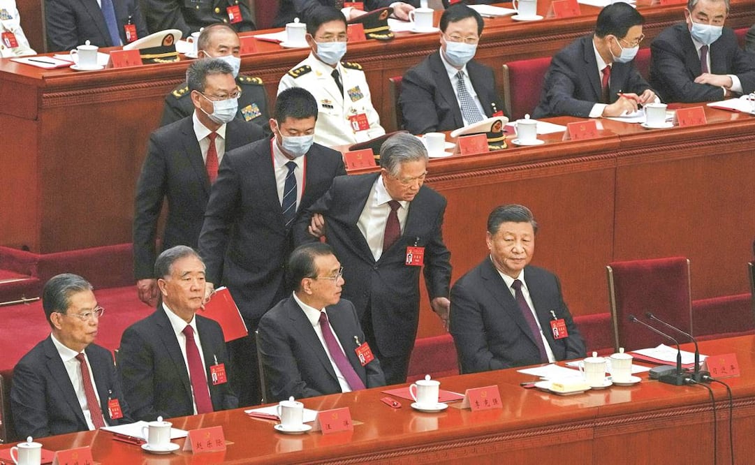 El expresidente Hu Jintao intenta hablar con su predecesor como líder del partido, Xi Jinping (der.), mientras lo acompañan a salir del salón durante la ceremonia de clausura del 20º Congreso Nacional del Partido Comunista de China en Beijing.