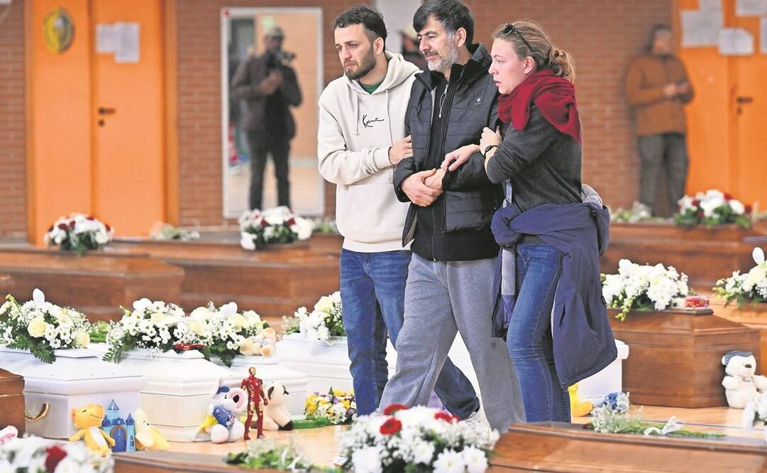 En un deportivo en Crotone, familiares y cercanos pasan junto a los ataúdes de las 65 víctimas de un naufragio de inmigrantes en Italia.