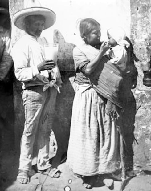Pareja compartiendo una jarra de pulque. La falta de recursos y vivir en sitios alejados orilló a algunas familias e infantes a beber pulque porque era más barato y sencillo de conseguir que la leche fresca. Foto: Mediateca INAH.
