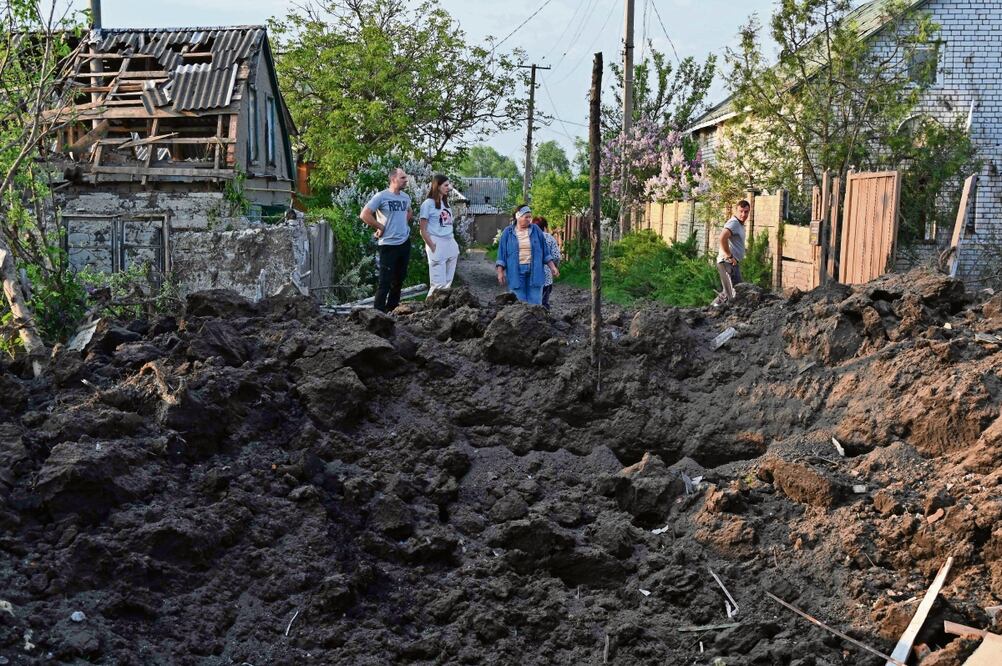Los residentes miran un cráter después de un ataque ruso con misiles en la aldea de Tsirkuny, región de Kharkiv, Ucrania, Foto: Sergey Bobok / AFP