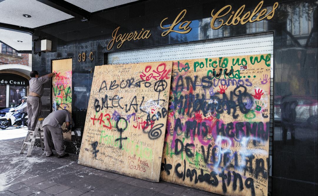 Trabajadores retiran los paneles de madera de los escaparates de joyerías del Centro Histórico, que fueron de los comercios más afectados por saqueos de la marcha del jueves. Foto: Hugo Salvador / EL UNIVERSAL