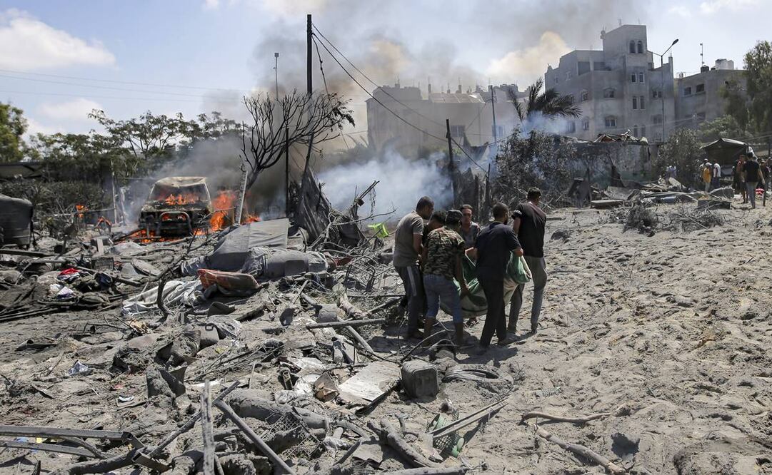 Palestinos evacuan un cadáver de un lugar alcanzado por un bombardeo israelí en Jan Yunis, en el sur de la Franja de Gaza. Foto AP/Jehad Alshrafi)
