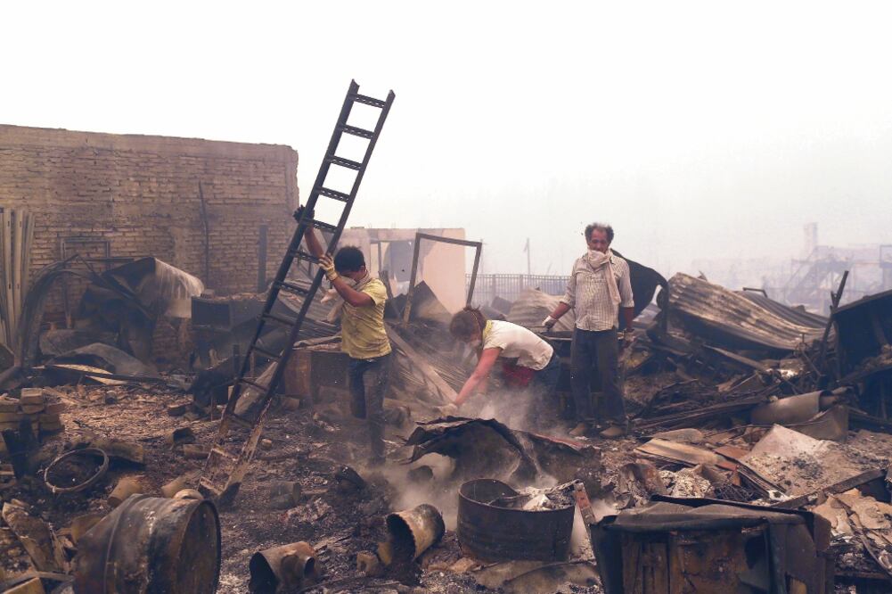 Chilenos buscan qué rescatar de entre los escombros de una casa quemada, en Santa Olga, una de las comunidades más afectadas por los peores incendios registrados en la historia moderna del país (PABLO SANHUEZA. REUTERS)