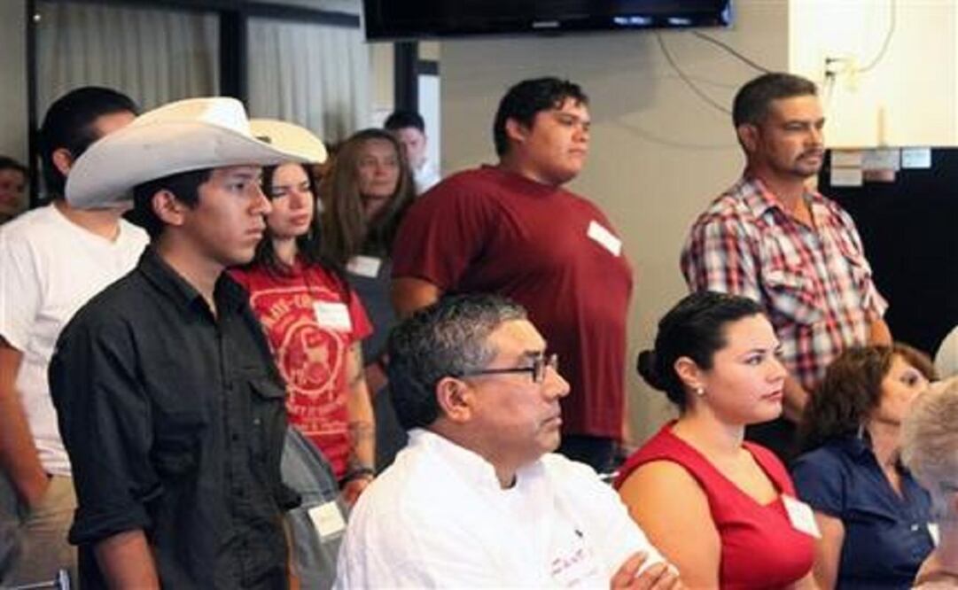 A group of young farmers and ranchers stand up as advocates speak about discrimination and civil rights violations involving Latinos and women during a news conference in Albuquerque, N.M., on Sept. 30, 2015 (Photo: AP) 
