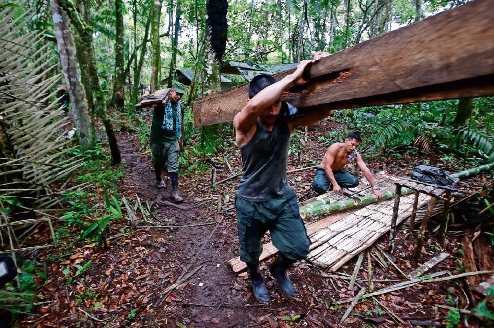 Miembros de las FARC trabajan en la construcción del complejo donde se alojará n las delegaciones que participarán en su congreso, en los Llanos del Yarí (JOHN VIZCAINO. REUTERS)