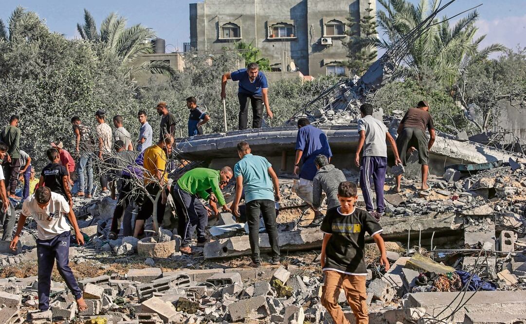 Palestinos buscan entre los escombros de una casa destruida tras los ataques aéreos israelíes en el campo de refugiados de Al-Maghazi. Foto: Mohammed Saber | EFE