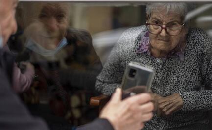 Desde hace un año, pareja de ancianos se ve a través de un cristal por el Covid en España