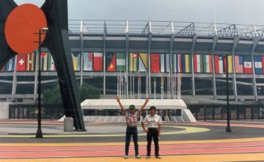 Fotografía compartida para EL UNIVERSAL por Miguel García Sánchez, en la que aparece junto con su hermano mayor en la explanada del Estadio Azteca, engalanado con banderas multicolores para la Copa Mundial de Futbol México 86. Junto a ellos se encuentra la escultura “El Sol Rojo”, realizada por el estadounidense Alexander Calder, parte de la Ruta de la Amistad que es hasta la fecha el símbolo del recinto. Foto: EL UNIVERSAL.