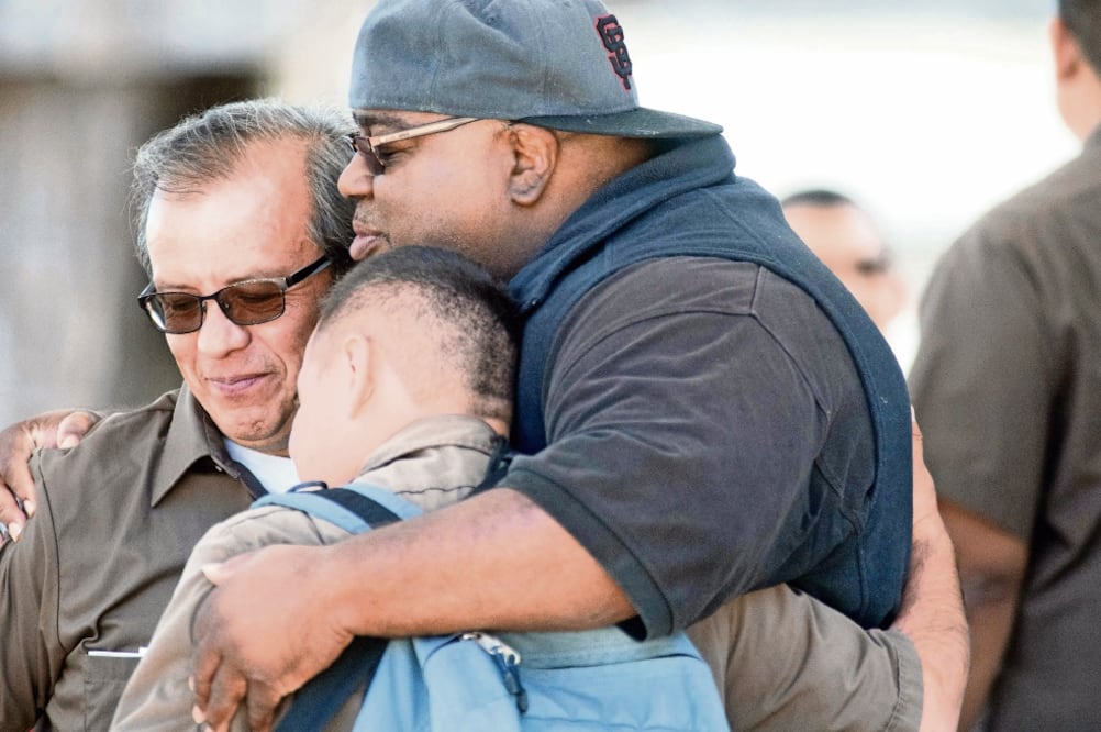 Trabajadores de UPS se abrazan luego de que un hombre abriera fuego y matara a tres compañeros en las oficinas de San Francisco. (JOSH EDELSON. AFP)