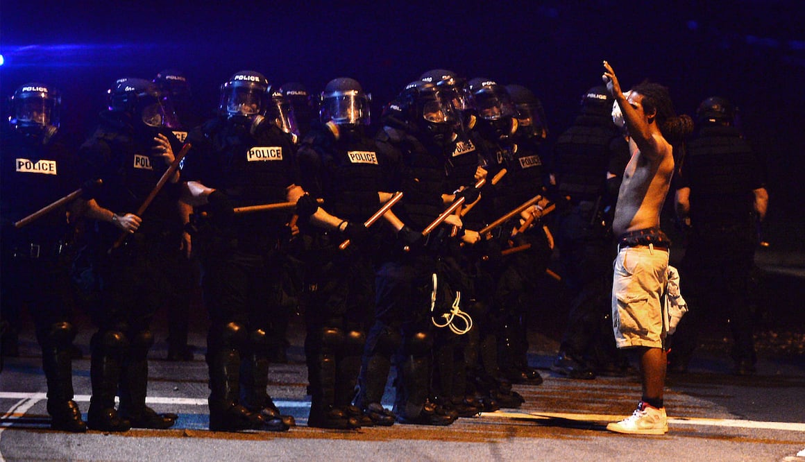 Un hombre alza las manos frente a un grupo de policías durante una protesta en la ciudad de Charlotte  (Foto: AP)