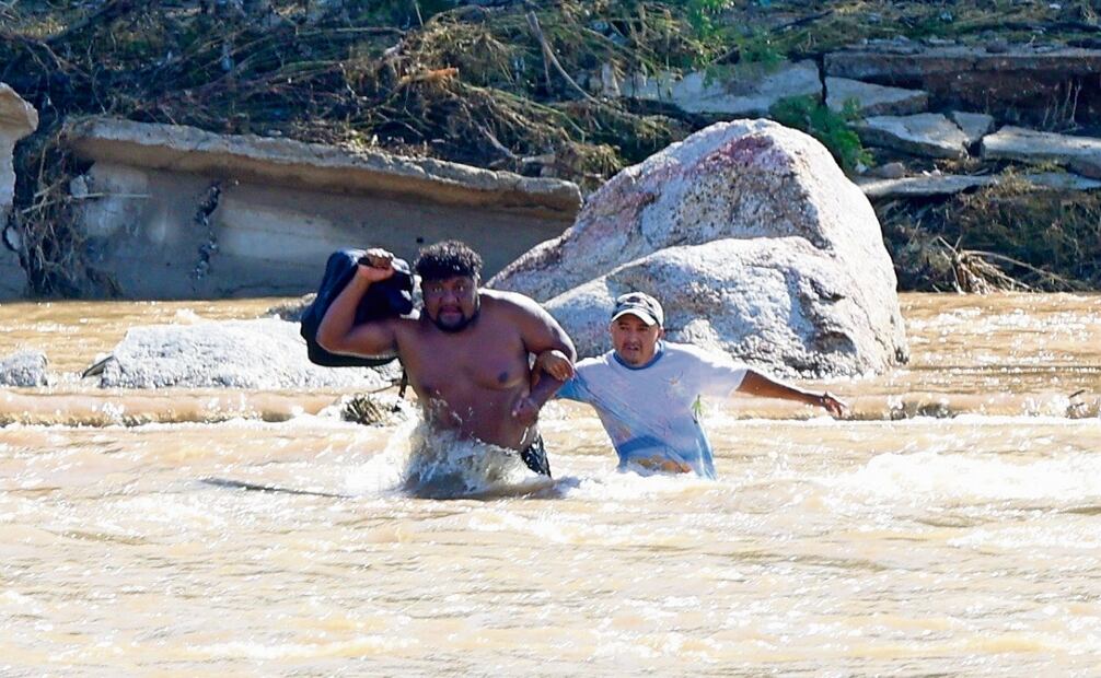 Moisés Gustavo Jaramillo García, El Demonio, gracias a su fuerza ayuda a sus vecinos a cruzar el río de la Sábana para que puedan llegar al centro de Acapulco. Foto: Valente Rosas | El Universal