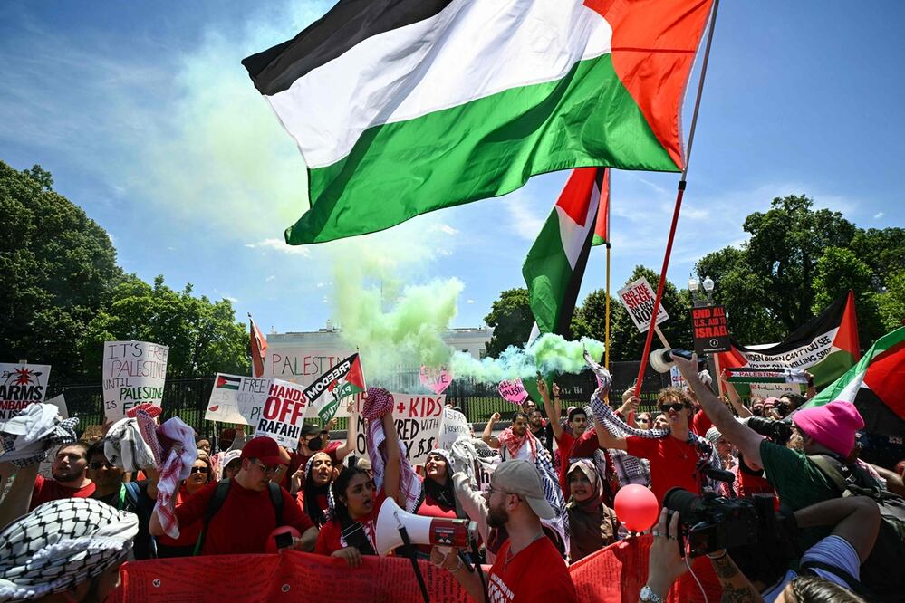 Manifestantes propalestinos liberan humo verde mientras se concentran cerca de la Casa Blanca en Washington. Foto: AFP