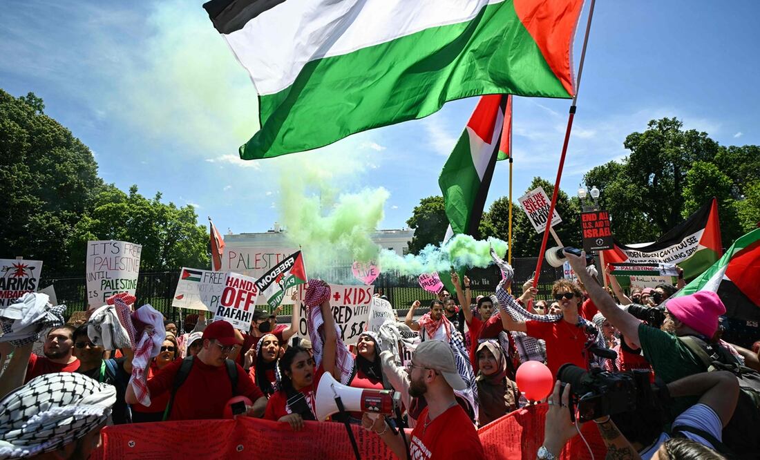 Manifestantes propalestinos liberan humo verde mientras se concentran cerca de la Casa Blanca en Washington. Foto: AFP