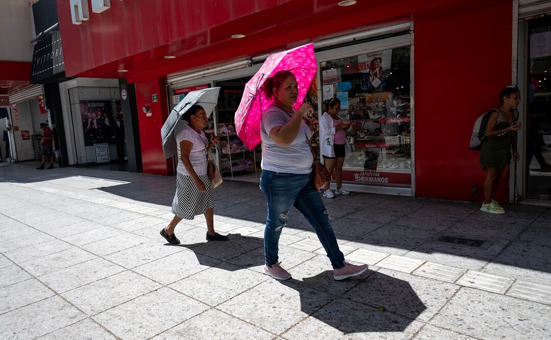 Mujeres sostienen sombrillas para protegerse del sol este miércoles, en la ciudad de Monterrey (México). El norte de México se prepara para afrontar este miércoles y jueves el pico de la segunda onda de calor con temperaturas de 45 grados o más, las más altas en lo que va del año. El Servicio Meteorológico Nacional (SMN) prevé temperaturas superiores a los 45 grados en los estados de Coahuila y Nuevo León, en la frontera noreste de México, donde las autoridades ya han atendido decenas de casos de personas afectadas por golpes de calor. EFE/Miguel Sierra