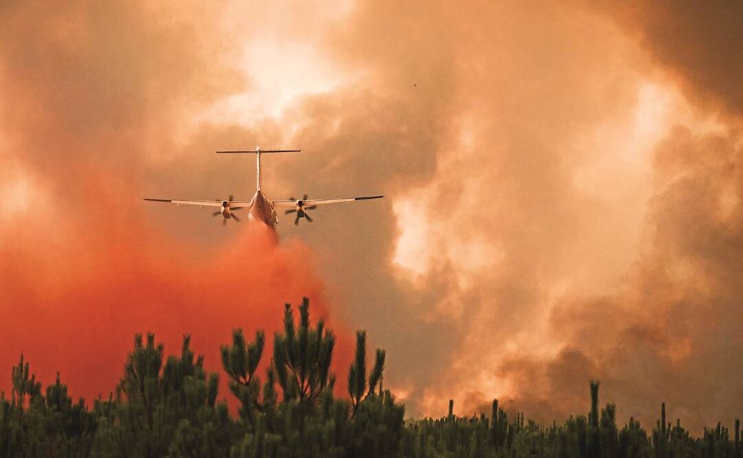 Mientras con un avión cisterna combaten un incendio forestal cerca de Belin-Béliet, en Gironda, bomberos luchan contra el fuego cerca de esa localidad. Foto: PHILIPPE LOPEZ/AFP 
