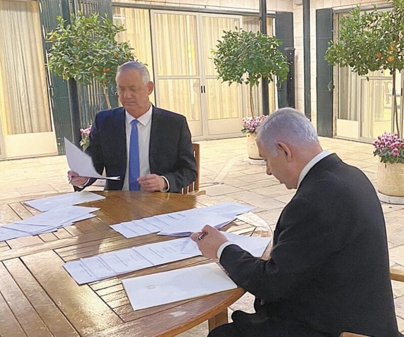 Se reúnen. El premier israelí Benjamin Netanyahu (de espaldas) y su ahora aliado, Benny Gantz. EFE