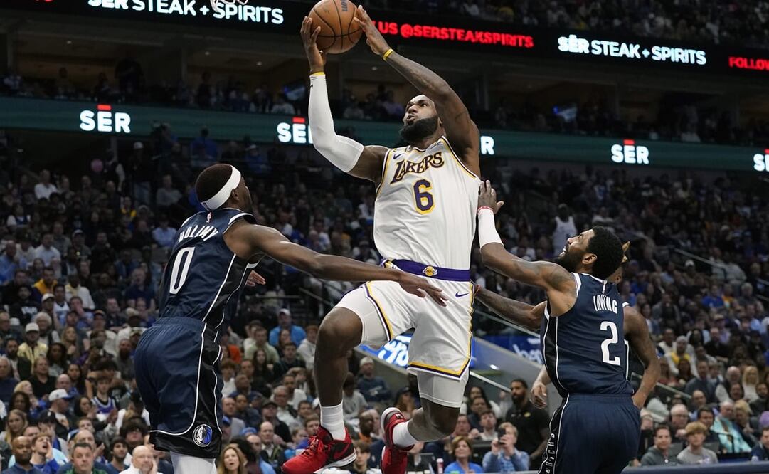 James elevándose sobre Kyrie Irving y Justin Holiday / Foto: AP