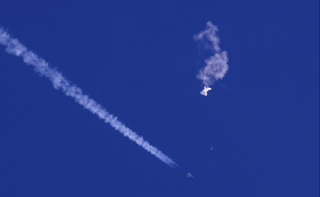 Restos del globo chino derribado sobre el océano Atlántico en la costa de Carolina del Sur con un avión de combate y su estela debajo, el sábado 4 de febrero. FOTO: AP