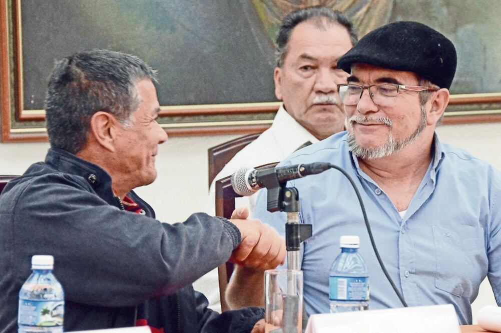 El jefe de las FARC, alias Timochenko (der.), estrecha la mano del comandante del ELN, alias Gabino, tras su reunión de ayer en La Habana. (JOAQUÍN HERNÁNDEZ. XINHUA)