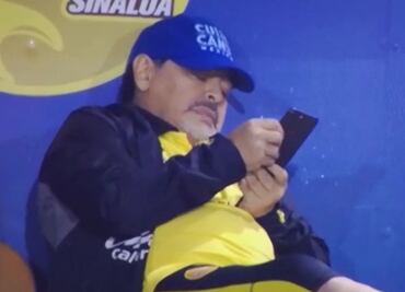 Maradona se aburre de sus Dorados y saca el celular