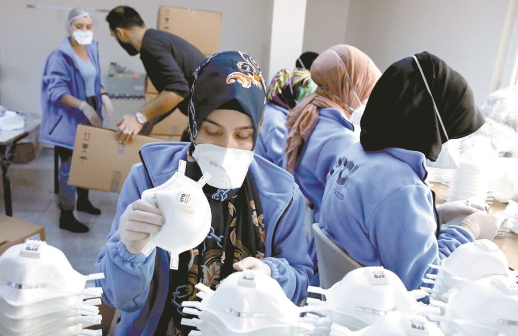 Empleados en una fábrica que hace cubrebocas en Estambul, Turquía. Los trabajadores han visto subir la demanda de sus productos ante el nuevo coronavirus. UMIT BEKTAS. REUTERS