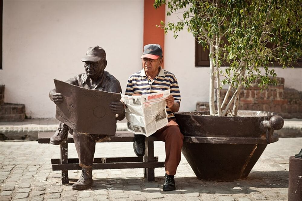 El cubano posa todos los días junto a su escultura de bronce. (Foto: Cecilia Lutufyan)
