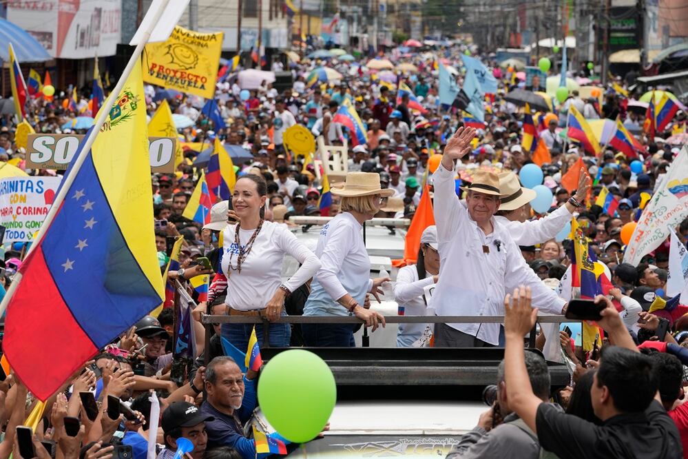 La líder opositora María Corina Machado, izquierda, y el candidato presidencial Edmundo González, desfilan en un camión que los transporta entre una multitud de partidarios durante un mitin de campaña en Barinas. Foto: AP