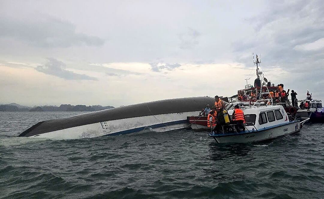 Esta fotografía tomada el 19 de julio de 2025 y publicada por la Agencia de Noticias de Vietnam (VNA) muestra al personal de socorro reunido alrededor de un barco turístico volcado durante una operación de búsqueda y rescate en la bahía de Ha Long, provincia de Quang Ninh. Foto: AFP