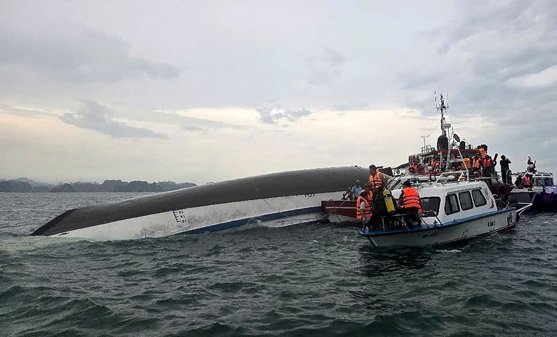 Esta fotografía tomada el 19 de julio de 2025 y publicada por la Agencia de Noticias de Vietnam (VNA) muestra al personal de socorro reunido alrededor de un barco turístico volcado durante una operación de búsqueda y rescate en la bahía de Ha Long, provincia de Quang Ninh. Foto: AFP