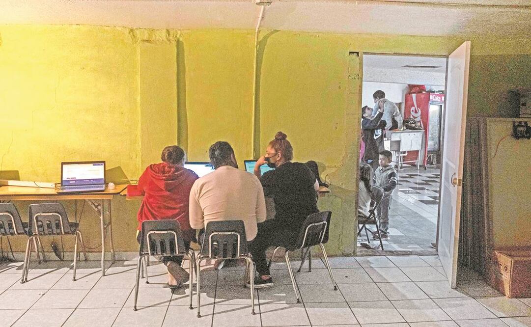 Una voluntaria del albergue Ágape, en Tijuana, ayuda a solicitantes de asilo a regis- trarse en el sitio del Alto Comisionado de las Naciones Unidas para los Refugiados. Foto: Guillermo Arias. AFP